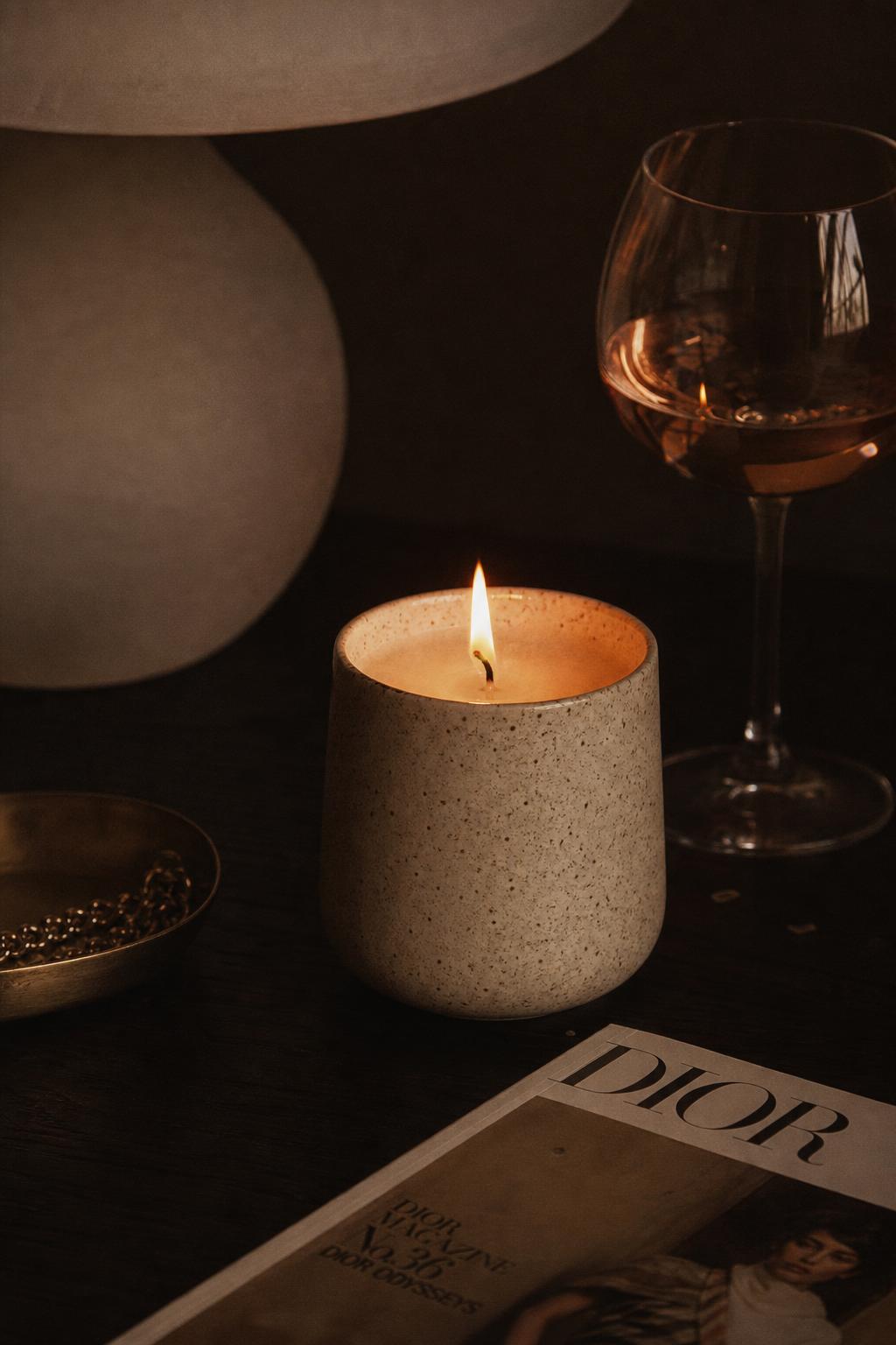 Speckled ceramic candle on warm wood